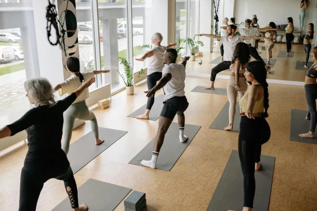 Groupe d’adultes en pleine séance de yoga collectif.