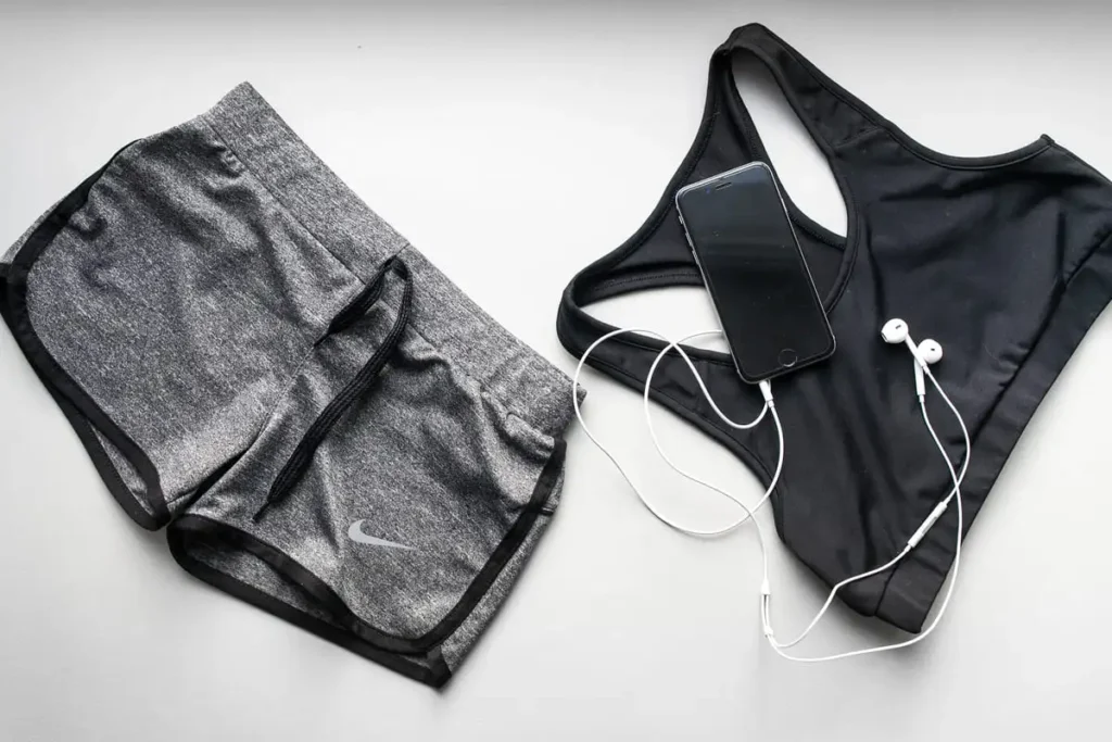 Tenue de sport confortable pour une séance de yoga, avec brassière, short, téléphone et écouteurs.